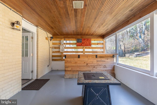 unfurnished sunroom with wood ceiling and a healthy amount of sunlight