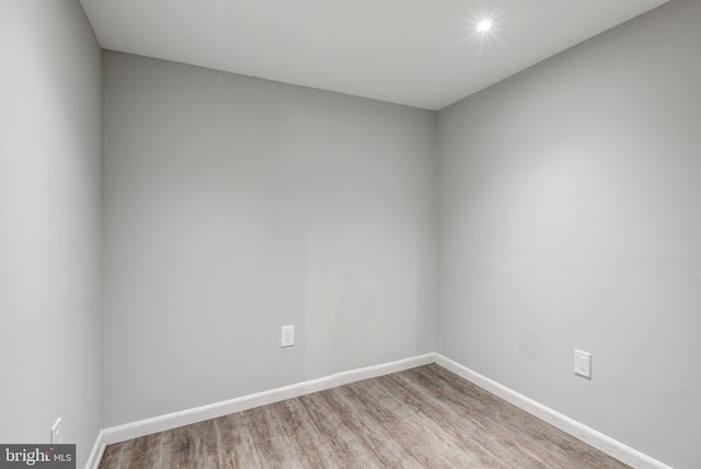 unfurnished room with baseboards and wood finished floors