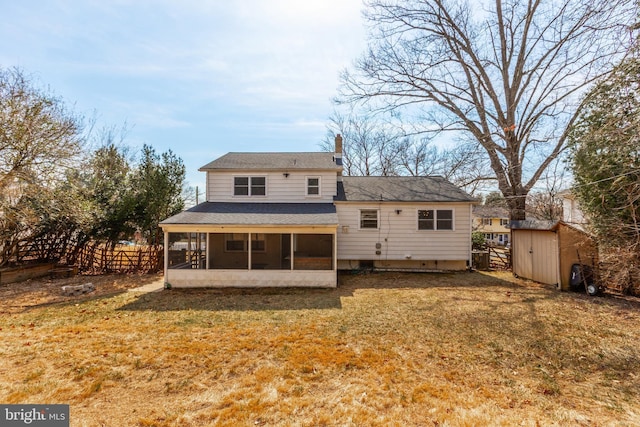 back of house with an outbuilding, fence, a sunroom, a storage unit, and a lawn