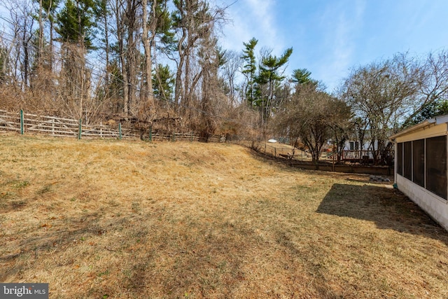 view of yard with a sunroom and fence