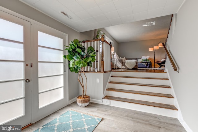 stairway with visible vents, plenty of natural light, french doors, and wood finished floors