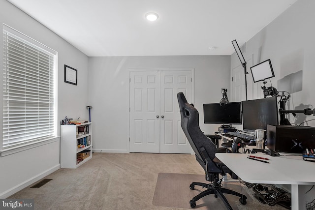 carpeted office space featuring visible vents and baseboards