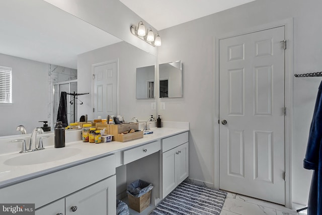 bathroom featuring marble finish floor, double vanity, a sink, and a shower stall