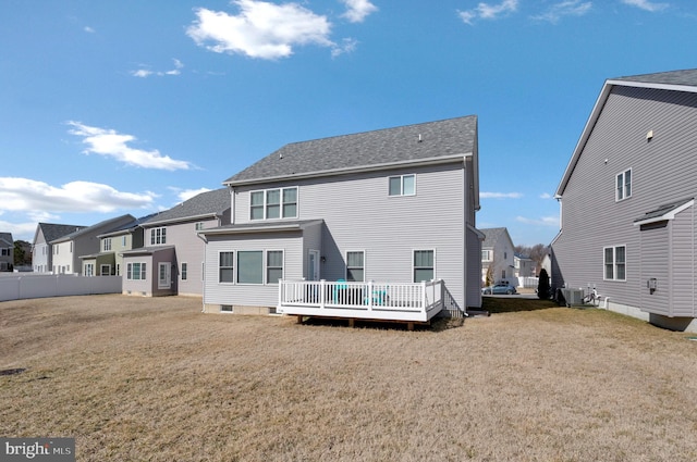 rear view of property with a wooden deck, a residential view, central AC unit, and a yard