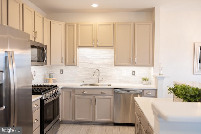 kitchen featuring decorative backsplash, appliances with stainless steel finishes, light countertops, and a sink