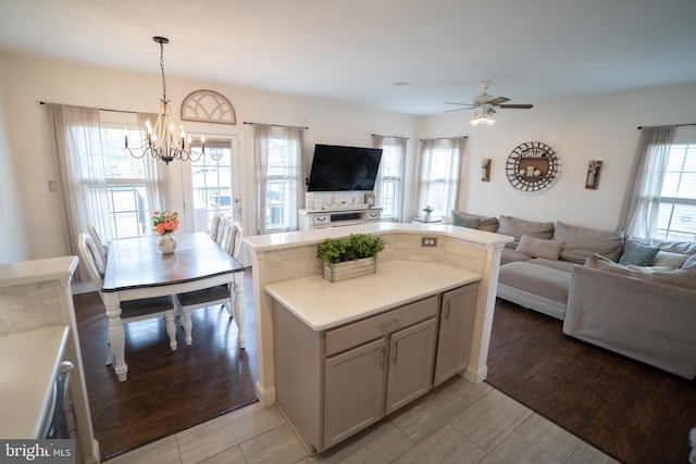 kitchen with hanging light fixtures, light countertops, open floor plan, and a center island