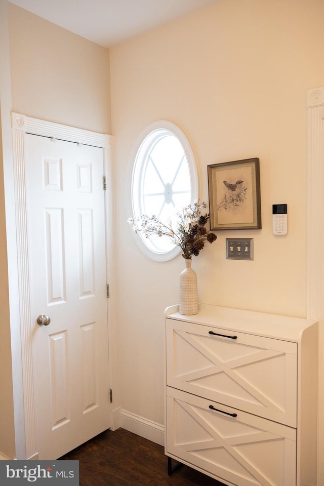 doorway to outside featuring dark wood finished floors and baseboards