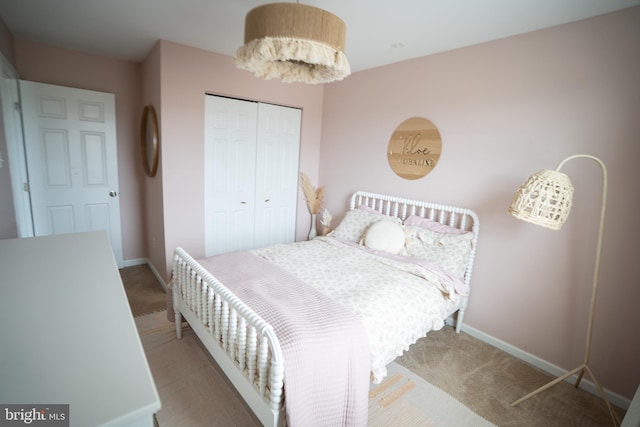 bedroom featuring a closet, baseboards, and carpet flooring