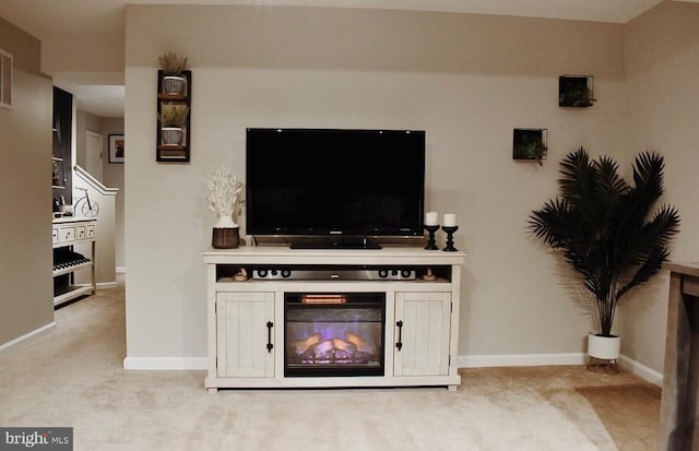 living area featuring a fireplace, baseboards, and light carpet