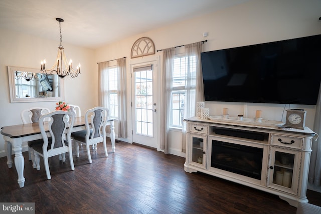 dining space with baseboards, dark wood-type flooring, and a chandelier