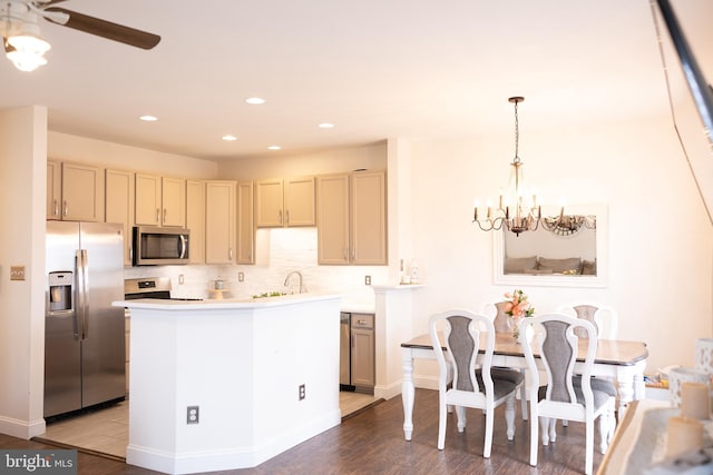 kitchen with backsplash, light countertops, recessed lighting, appliances with stainless steel finishes, and wood finished floors