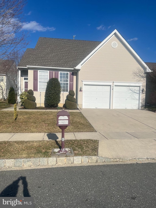 single story home featuring a garage, roof with shingles, and driveway