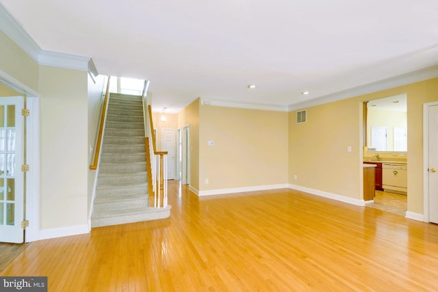 interior space with visible vents, baseboards, ornamental molding, stairs, and light wood-type flooring