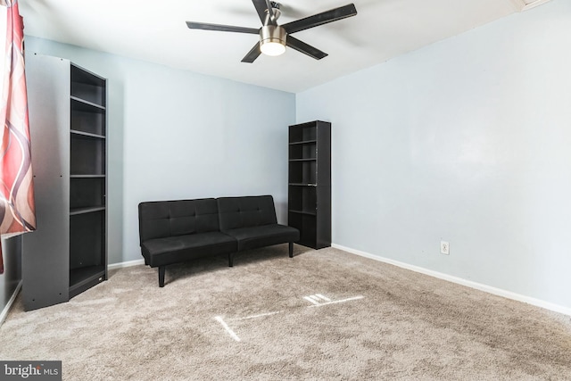 living area featuring ceiling fan, baseboards, and carpet floors