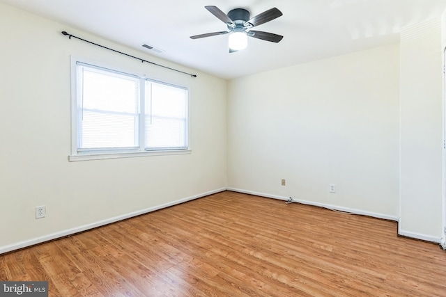 empty room with light wood finished floors, visible vents, ceiling fan, and baseboards