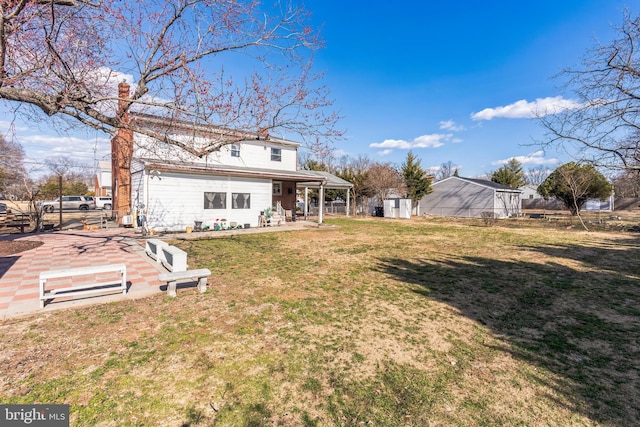 back of property with a patio area, a lawn, and fence