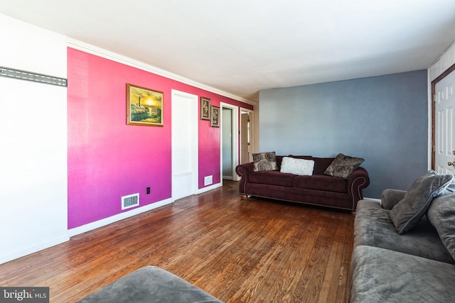 living room featuring visible vents, baseboards, and wood finished floors