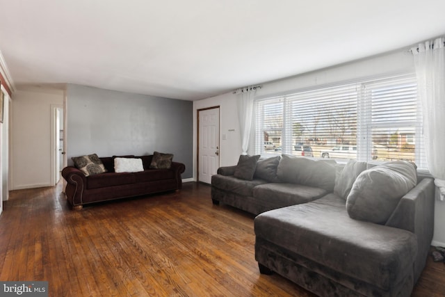 living room with dark wood-type flooring and baseboards