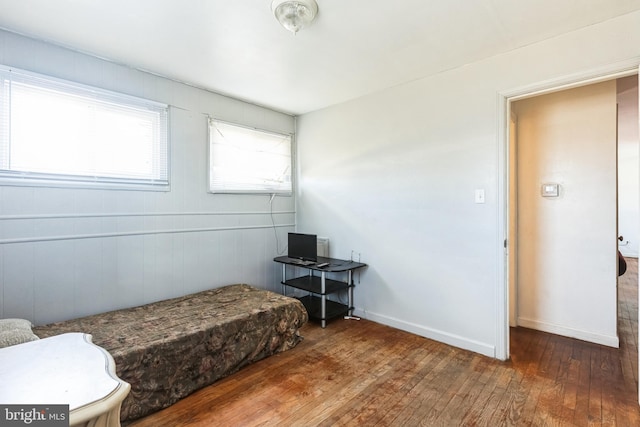 bedroom featuring baseboards and hardwood / wood-style floors