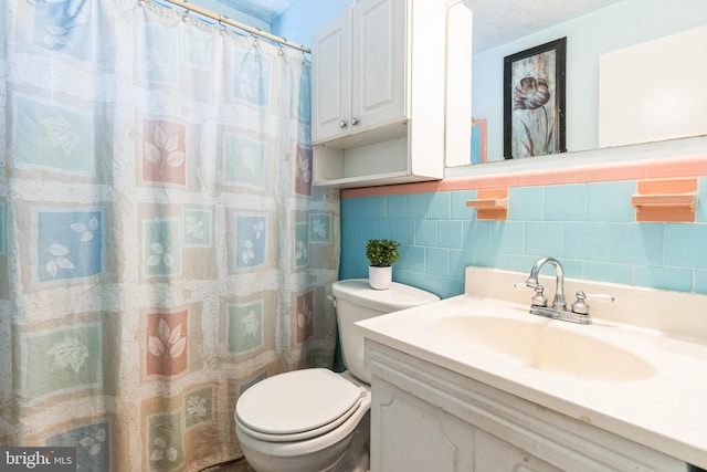 full bathroom with toilet, tile walls, and vanity