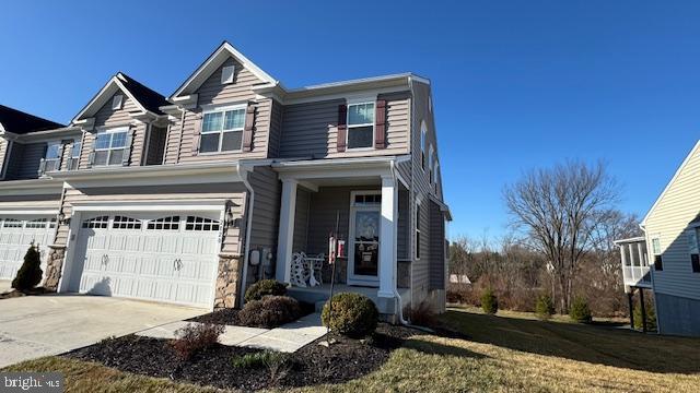 view of front of house featuring concrete driveway, an attached garage, and a front yard