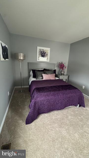 carpeted bedroom featuring visible vents and baseboards