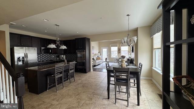dining area featuring baseboards and an inviting chandelier