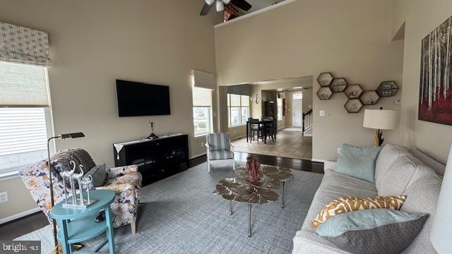 living area with a high ceiling and a ceiling fan