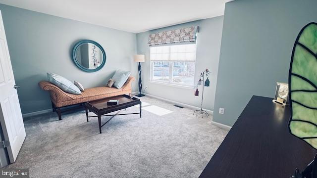 living area with baseboards and carpet floors