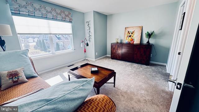 living area featuring baseboards and carpet flooring