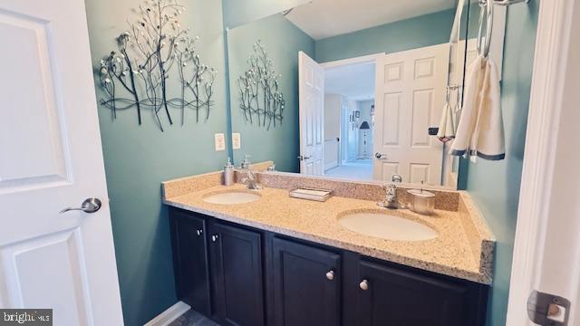 bathroom with a sink and double vanity