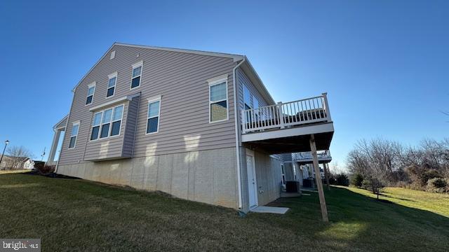 view of property exterior featuring a yard and a wooden deck