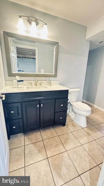 bathroom featuring tile patterned flooring, toilet, vanity, and visible vents
