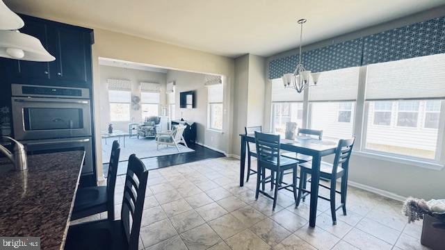 dining room featuring an inviting chandelier and baseboards