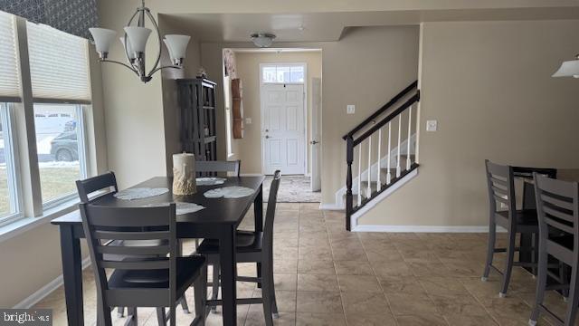 tiled dining space with stairs and baseboards