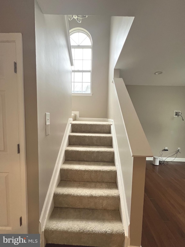 stairway featuring baseboards and wood finished floors
