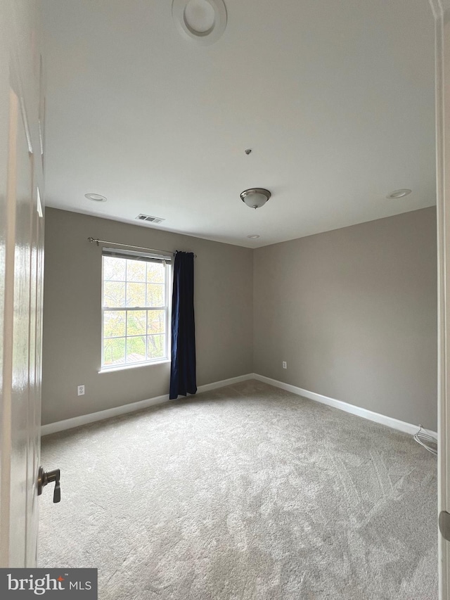 unfurnished room featuring visible vents, baseboards, and carpet floors