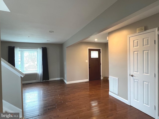 foyer entrance featuring a healthy amount of sunlight, dark wood-style flooring, baseboards, and visible vents