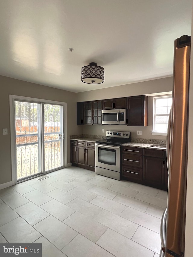 kitchen with visible vents, baseboards, light countertops, dark brown cabinetry, and stainless steel appliances