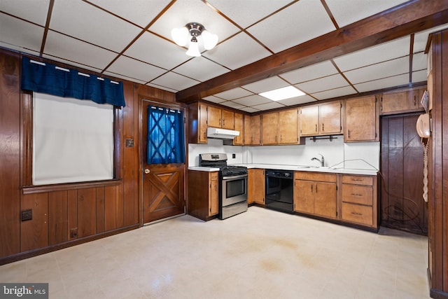 kitchen with wooden walls, stainless steel range with gas cooktop, under cabinet range hood, dishwasher, and light countertops