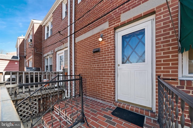 view of exterior entry with brick siding