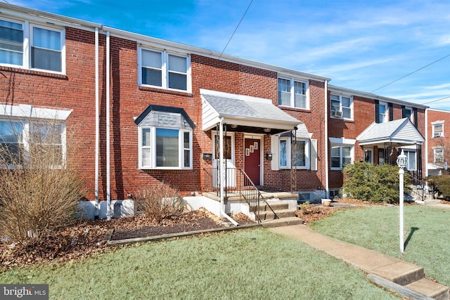 view of property featuring brick siding and a front yard