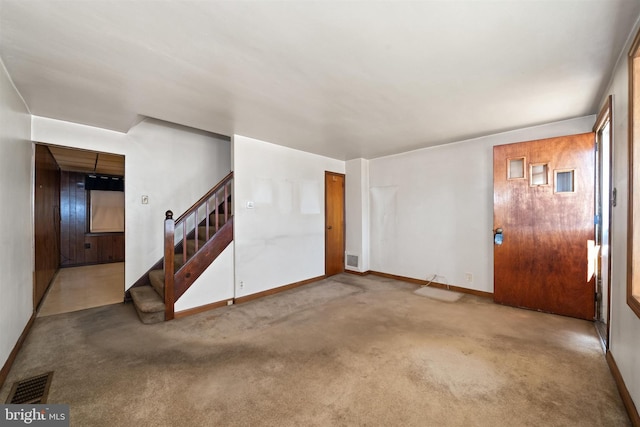 unfurnished living room with stairs, carpet flooring, baseboards, and visible vents