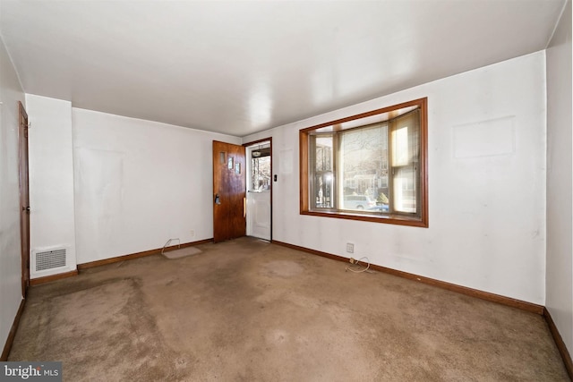 carpeted spare room with visible vents and baseboards