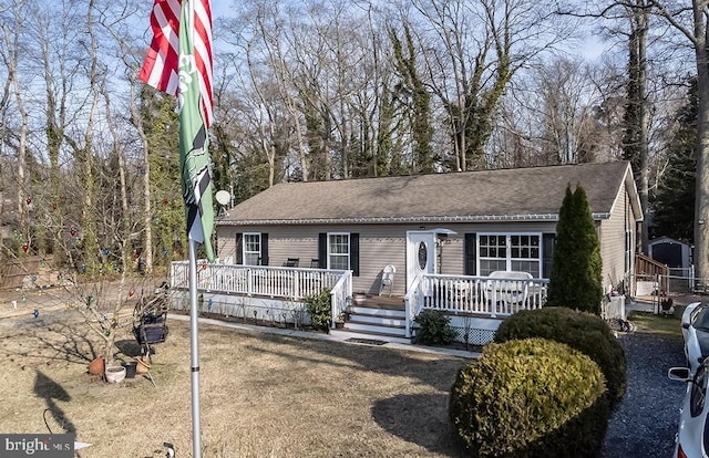 single story home featuring roof with shingles and a wooden deck