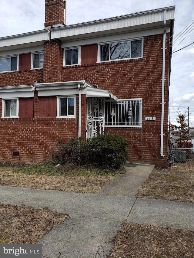 townhome / multi-family property with crawl space, a chimney, and brick siding