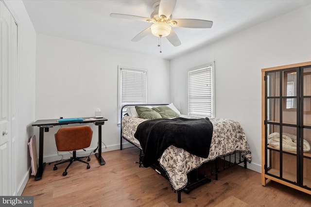 bedroom featuring baseboards, ceiling fan, and light wood finished floors