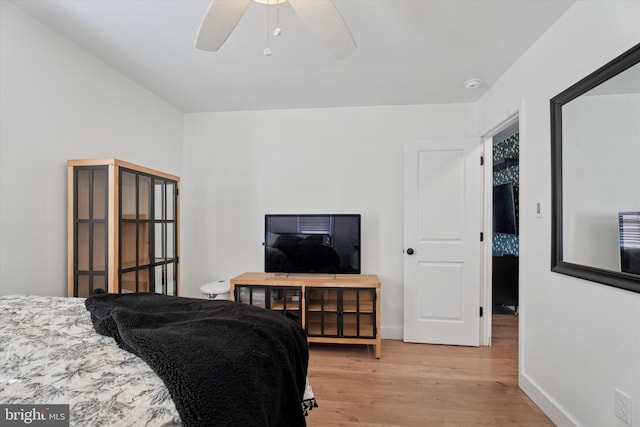 bedroom featuring a ceiling fan, light wood-type flooring, and baseboards