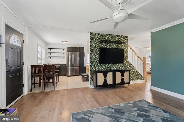 entrance foyer featuring light wood-type flooring, baseboards, ceiling fan, and stairway