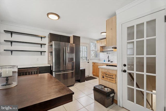 kitchen with open shelves, a sink, tasteful backsplash, freestanding refrigerator, and light tile patterned flooring